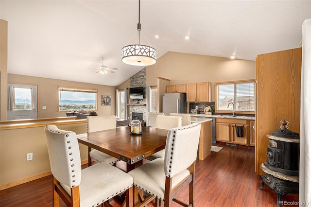 2418 Wells Fargo Cir, Jefferson, CO 80456 - dining space featuring ceiling fan, a fireplace, dark wood finished floors, plenty of natural light, and high vaulted ceiling