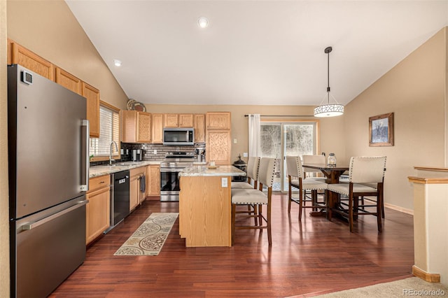 2418 Wells Fargo Cir, Jefferson, CO 80456 - kitchen featuring stainless steel appliances, vaulted ceiling, a sink, healthy amount of natural light, and light brown cabinetry