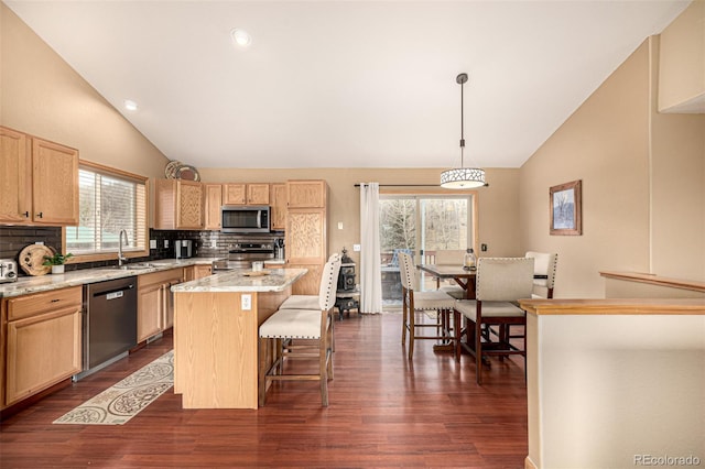 2418 Wells Fargo Cir, Jefferson, CO 80456 - kitchen with appliances with stainless steel finishes, tasteful backsplash, a center island, healthy amount of natural light, and high vaulted ceiling