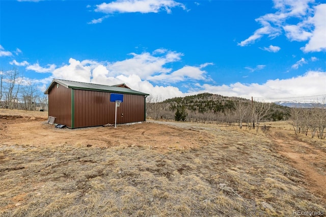 2418 Wells Fargo Cir, Jefferson, CO 80456 - view of yard featuring an outdoor structure, an outbuilding, a mountain view, and a view of rural / pastoral area