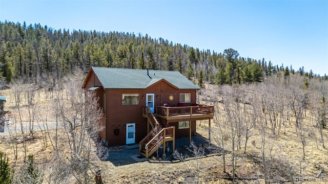2418 Wells Fargo Cir, Jefferson, CO 80456 - back of property featuring a forest view, a deck, and stairs