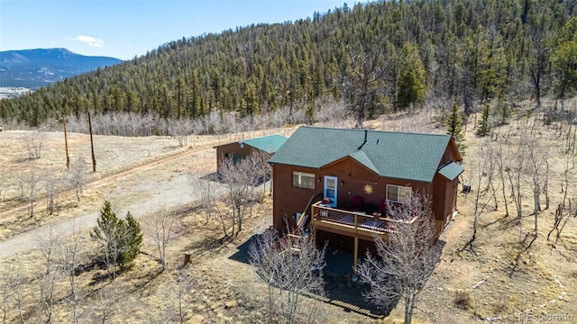 2418 Wells Fargo Cir, Jefferson, CO 80456 - back of property with a view of trees, a deck with mountain view, and roof with shingles