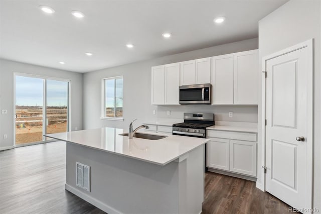 14424 Heritage Dr, Mead, CO 80504 - kitchen with appliances with stainless steel finishes, white cabinetry, a kitchen island with sink, light countertops, and recessed lighting