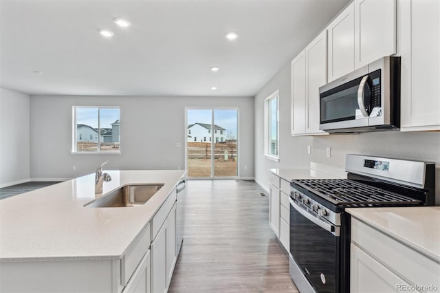 14424 Heritage Dr, Mead, CO 80504 - kitchen featuring stainless steel appliances, light wood-type flooring, white cabinetry, recessed lighting, and open floor plan