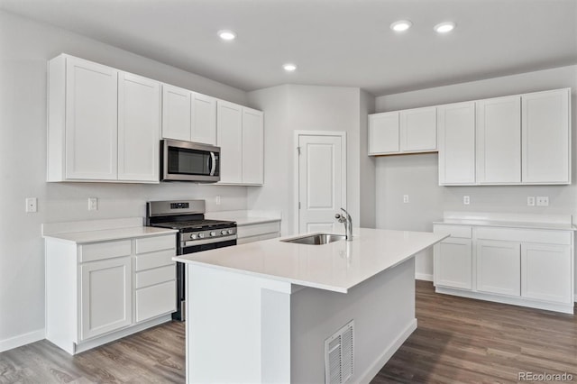 14424 Heritage Dr, Mead, CO 80504 - kitchen with appliances with stainless steel finishes, white cabinets, dark wood-style flooring, a center island with sink, and recessed lighting