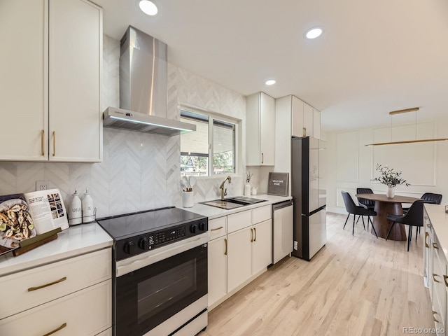920 S Hudson St, Denver, CO 80246 - kitchen featuring stainless steel appliances, wall chimney exhaust hood, a sink, light countertops, and white cabinetry