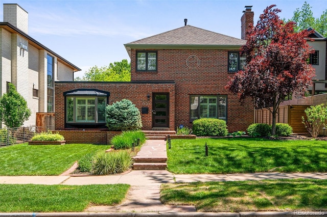 view of front of home with brick siding and a chimney