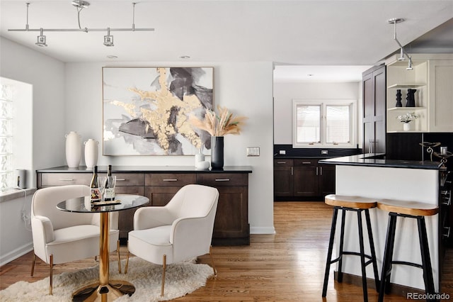 dining area featuring light wood-style floors and baseboards