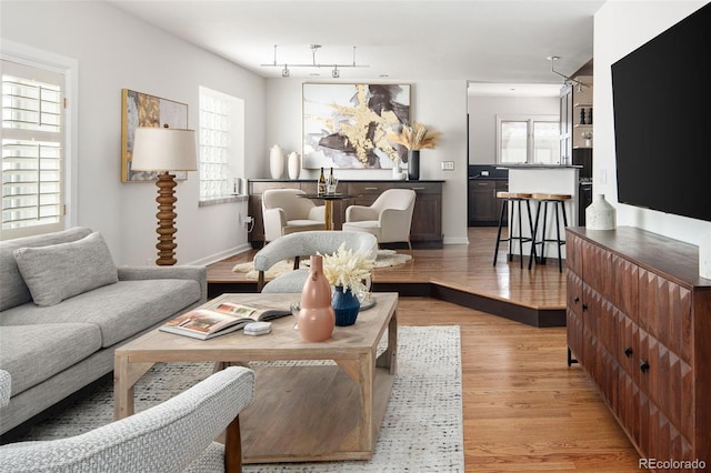living area featuring light wood-type flooring and baseboards