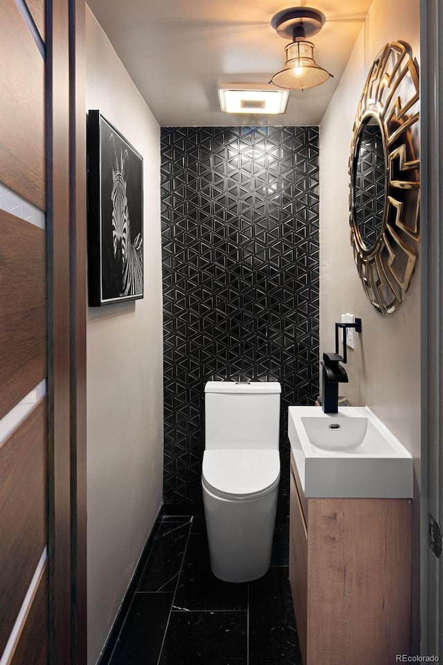 bathroom with toilet, vanity, and tile patterned floors
