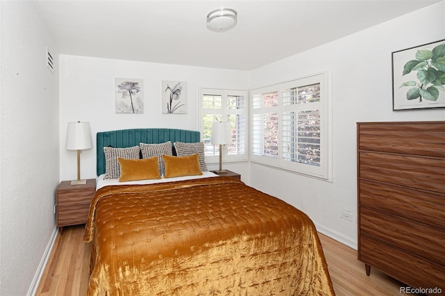 bedroom featuring wood finished floors and baseboards