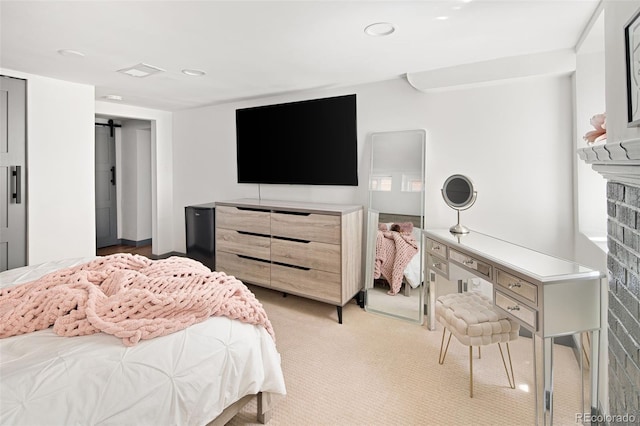 bedroom with light carpet, a barn door, and recessed lighting