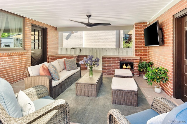 view of patio with an outdoor living space with a fireplace and a ceiling fan