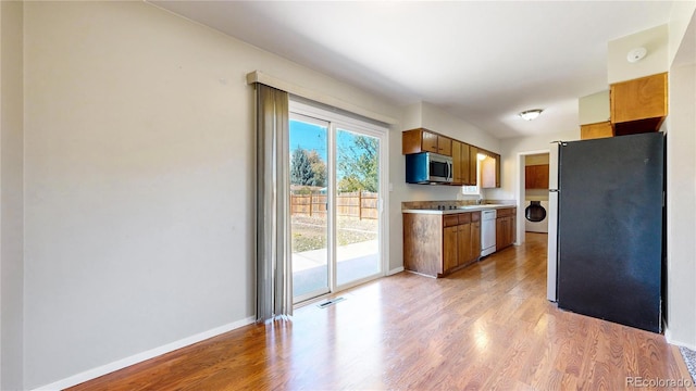 kitchen featuring appliances with stainless steel finishes, sink, and light wood-type flooring