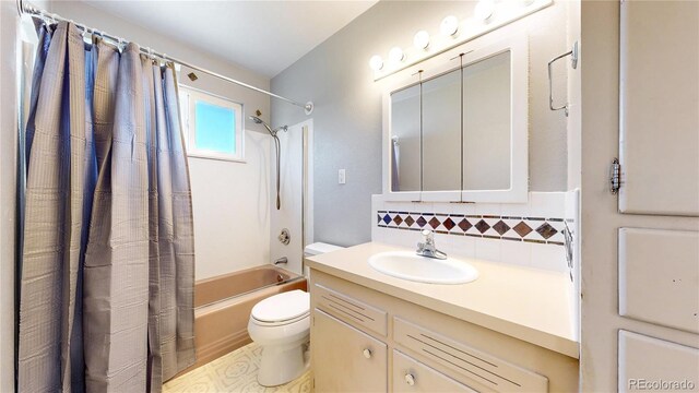 full bathroom featuring toilet, shower / bath combo with shower curtain, vanity, and backsplash