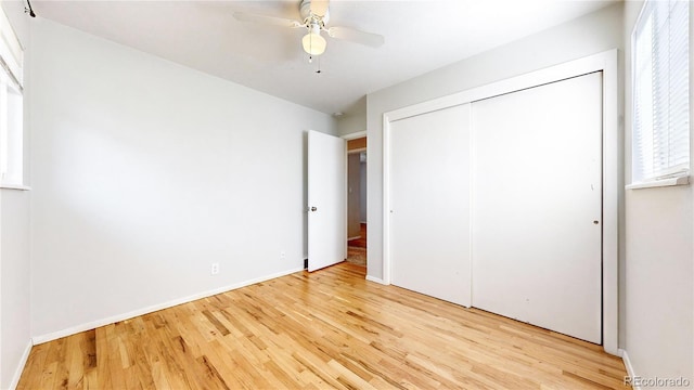 unfurnished bedroom featuring a closet, light wood-type flooring, and ceiling fan