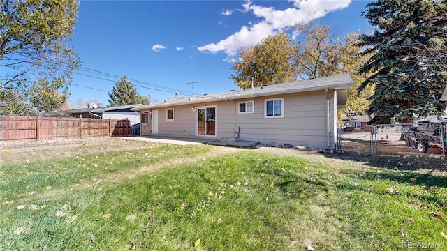 rear view of property featuring a lawn