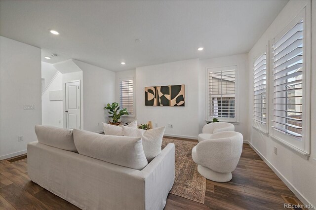 living room featuring recessed lighting, dark wood-style flooring, and baseboards