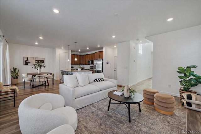 living area featuring light wood-type flooring, baseboards, and recessed lighting