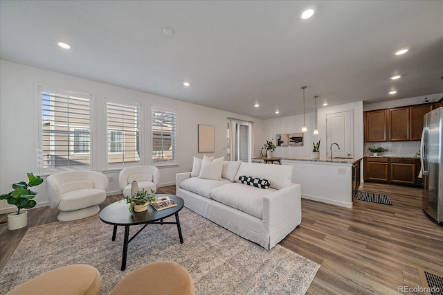 living area featuring recessed lighting, visible vents, and wood finished floors