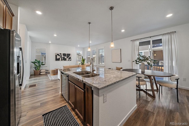 kitchen featuring recessed lighting, stainless steel appliances, a sink, and wood finished floors