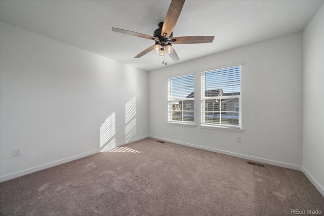 spare room featuring ceiling fan, carpet flooring, visible vents, and baseboards