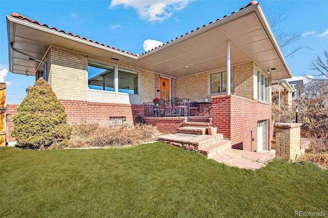 exterior space featuring a front lawn and brick siding