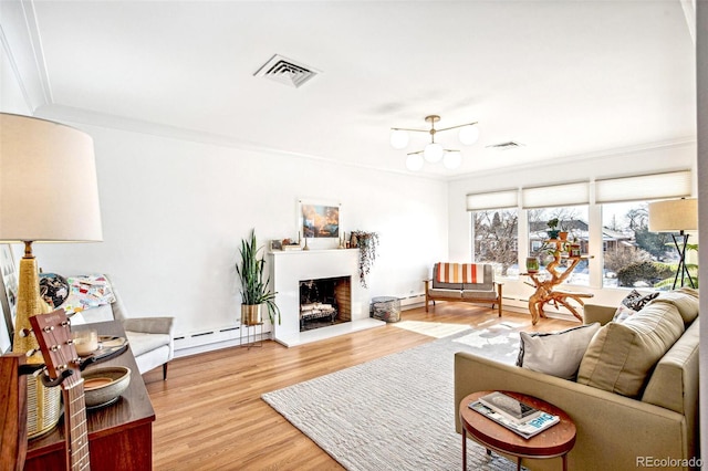 living room featuring crown molding, a baseboard radiator, and wood-type flooring