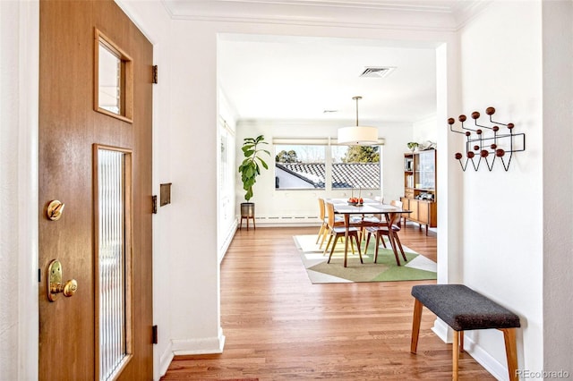 hallway featuring hardwood / wood-style flooring, a baseboard radiator, and crown molding