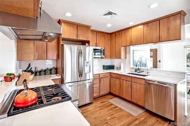 kitchen featuring sink, appliances with stainless steel finishes, backsplash, range hood, and light hardwood / wood-style floors