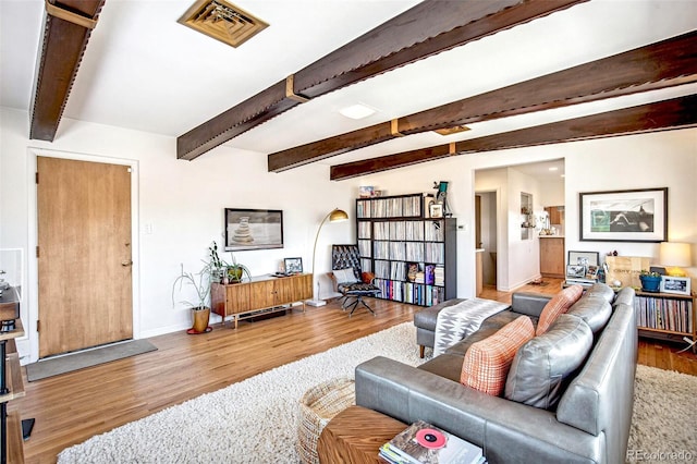 living room with beam ceiling and light wood-type flooring