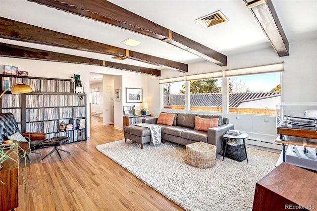 living room featuring light hardwood / wood-style floors, beamed ceiling, and baseboard heating