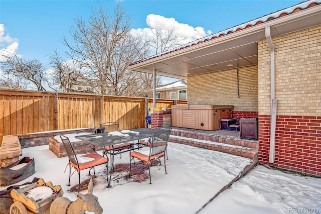 snow covered patio featuring a hot tub