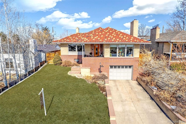 view of front facade featuring driveway, a chimney, an attached garage, a front lawn, and brick siding