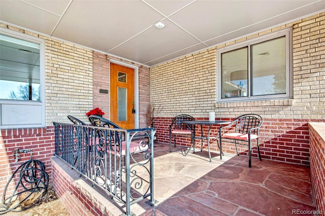 entrance to property with brick siding and a patio area