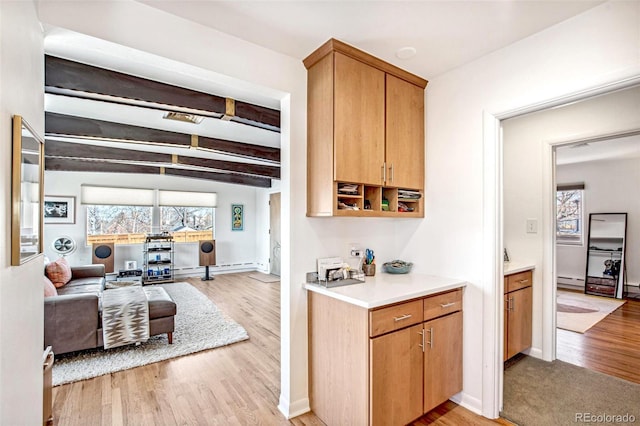 bar featuring baseboards, beamed ceiling, baseboard heating, and light wood-style floors