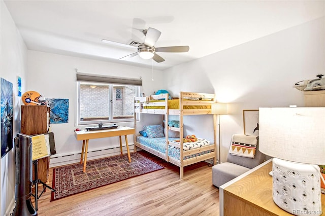 bedroom with a baseboard radiator, ceiling fan, and wood finished floors