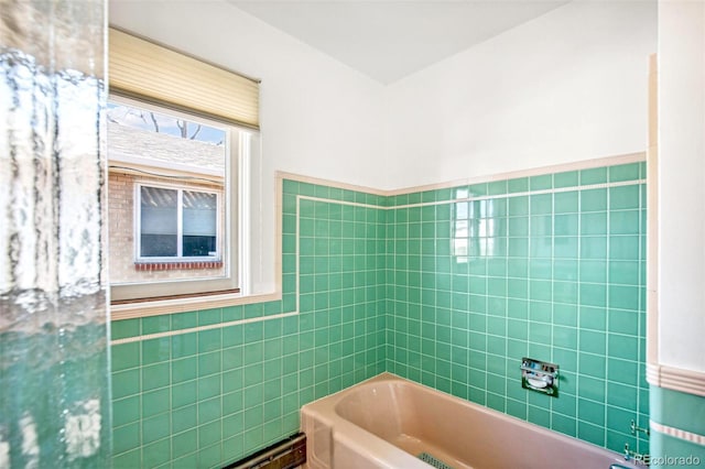 bathroom with wainscoting, shower / tub combination, and tile walls