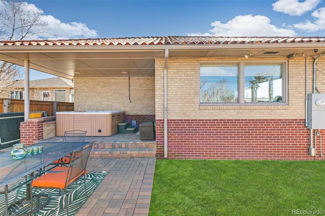 view of patio / terrace featuring a hot tub and fence