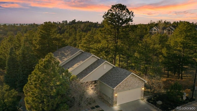 drone / aerial view with a wooded view