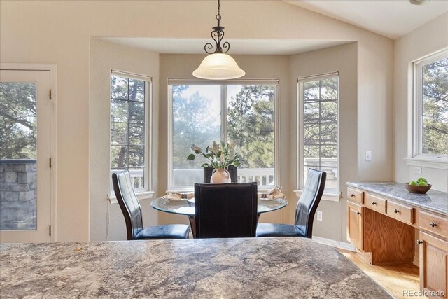 dining space featuring lofted ceiling and light wood-style floors