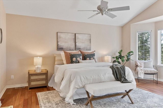 bedroom featuring baseboards, visible vents, lofted ceiling, ceiling fan, and wood finished floors