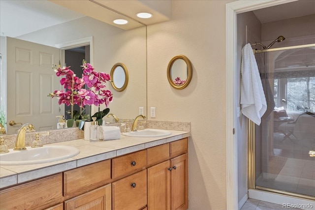 full bath featuring double vanity, a shower stall, and a sink