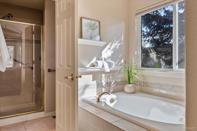 bathroom with a stall shower, tile patterned flooring, and a garden tub