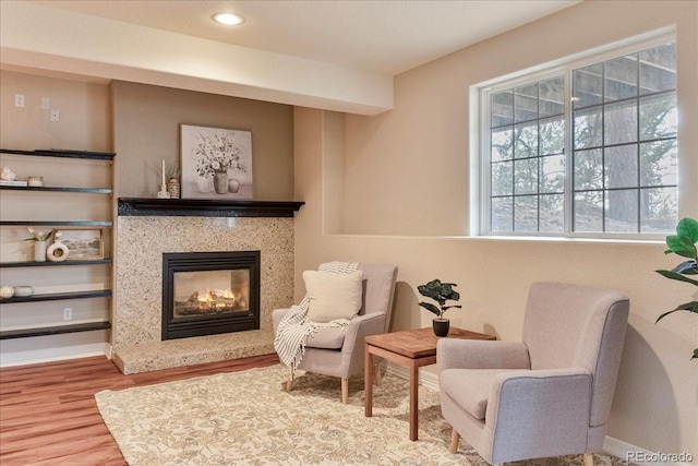 sitting room with recessed lighting, a fireplace, wood finished floors, and baseboards