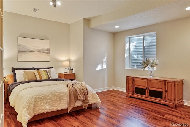 bedroom with baseboards, wood finished floors, and recessed lighting