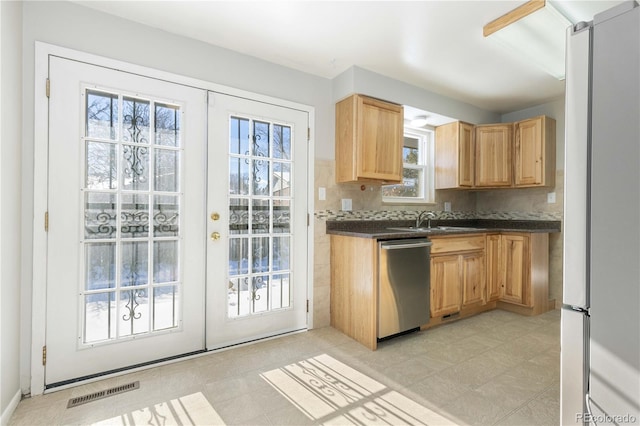 kitchen featuring french doors, sink, tasteful backsplash, stainless steel dishwasher, and white fridge