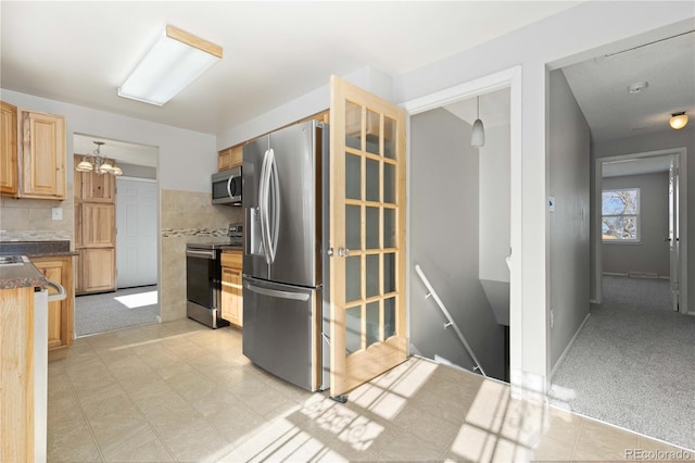 kitchen featuring pendant lighting, light brown cabinets, light carpet, appliances with stainless steel finishes, and tasteful backsplash