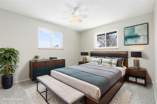 bedroom with multiple windows, ceiling fan, light colored carpet, and a textured ceiling