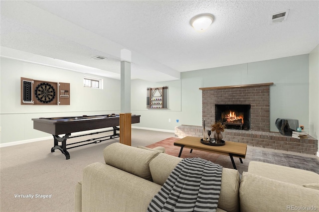 living room featuring a fireplace, carpet, and a textured ceiling